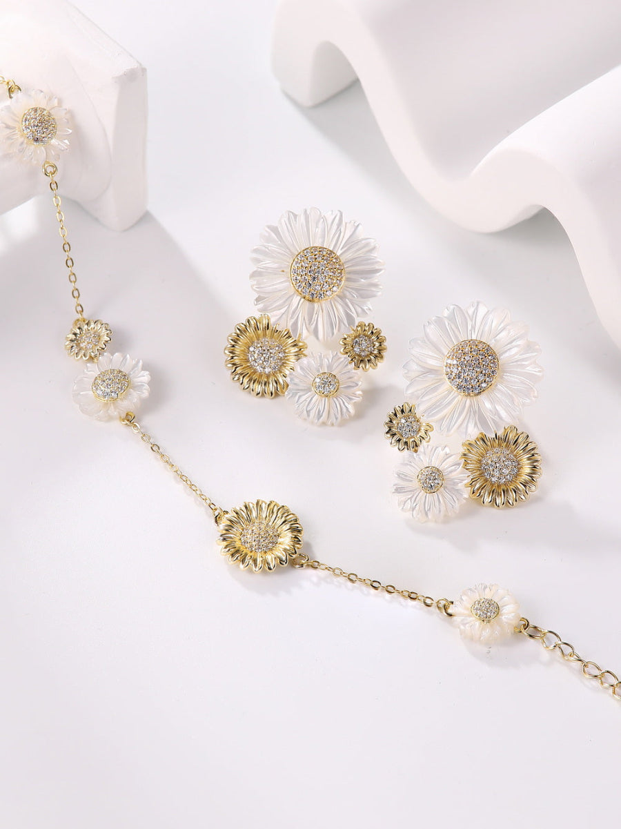 These exquisite double sunflower earrings are made from 14K gold-plated sterling silver and feature sparkling 5A cubic zirconia stones along with white mother of pearl. The earrings are designed with a post back for a secure fit. Each earring measures 1 inch (3 cm) in length and 1 inch (2.5 cm) in width. This elegant piece is from the Joy & Rachel brand.